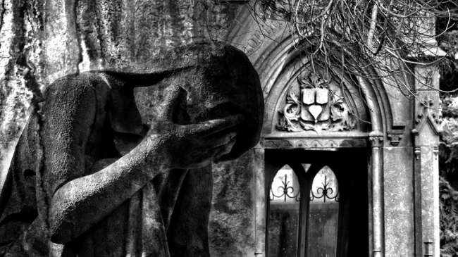 Foto hard al cimitero: vestita da suora, distesa sulle tombe