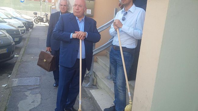 Rifugiati politici assediati dai leader della destra Storace e Donzelli, armati di scope